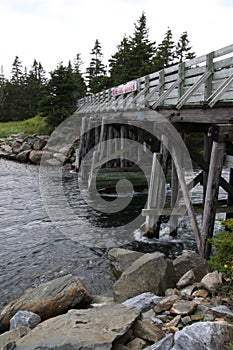 A wooden  bridge crossing a dangerously fast river