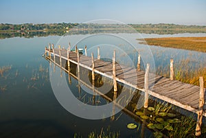 Wooden bridge on the lake. Beautiful landscape overlooking the lake in Coba. Mexico, Yucatan.