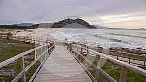 Wooden bridge leading to the Louro peak beach on a gloomy day in Galacia Spain