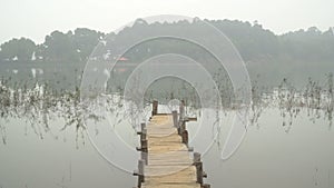 Wooden bridge in the misty lake