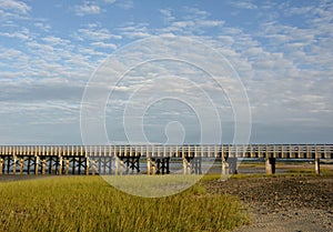 Wooden Bridge Over Bay with Marsh Grass at Low Tide