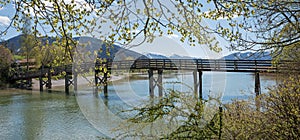 Wooden bridge over mangfall river, view to lake tegernsee