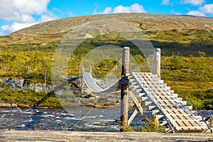 Wooden bridge over the mountain river