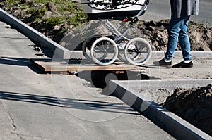 Wooden bridge over a pit. repairing the road surface and installing curbs