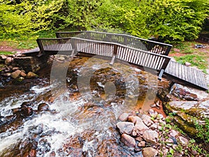 Wooden bridge over river in green forest. Balkan mountains, Serbia