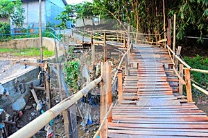 wooden bridge over the river surface as a means of access to community roads