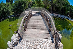 Wooden bridge over the small artificial lake at the National Garden of Athens city