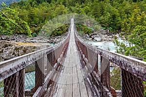 Wooden bridge over Ventisquero River on trail to Glacier, near the village of Puyuhuapi, Chile. photo