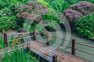 Wooden bridge over water among trees at Portland Japanese Garden, Portland, Oregon