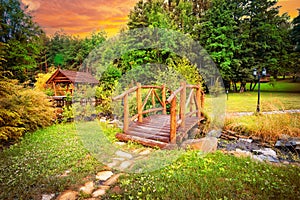 Wooden bridge in park at sunset