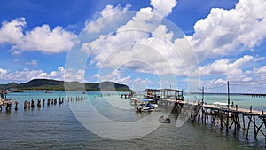 Wooden bridge pathway for group of people, tour, tourist walk to get in speedboat and longtail boat to take trip on sea