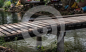 Wooden bridge pathway over a rural small canal. Crossing to the other side