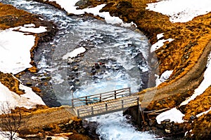 The wooden bridge of rapid flow of the river