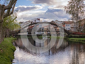 Wooden bridge reflected on the water of the river Cabe as it passes through the city of Monforte de Lemos
