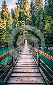 A wooden bridge spanning across a flowing river.