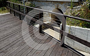 Wooden bridge with a stone foundation newly built for cyclists over a stream by the pond. wooden beams connected by screws and rop