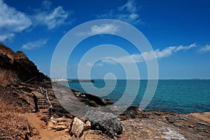 Wooden bridge walkway along the rocks coast and sea with blue sky summer time