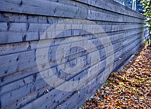 Wooden brown opaque fence with horizontally attached planks. fence as protection against noise from cars driving on the street. au