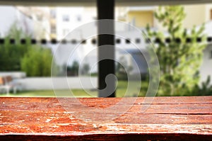 Wooden brown table top against the blurred corridor, passage and courtyard of the house .For product display montage or