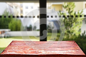 Wooden brown table top against the blurred corridor, passage and courtyard of the house .For product display montage or