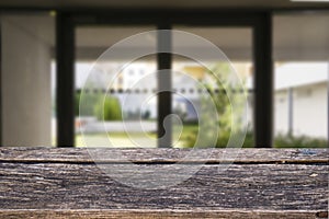 Wooden brown table top against the blurred corridor, passage and courtyard of the house .For product display montage or