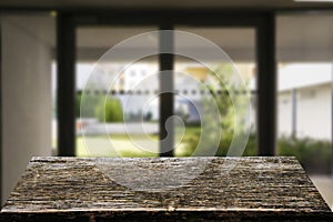 Wooden brown table top against the blurred corridor, passage and courtyard of the house .For product display montage or