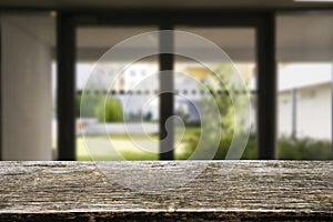 Wooden brown table top against the blurred corridor, passage and courtyard of the house .For product display montage or