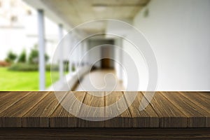 Wooden brown table top against the blurred corridor, passage and courtyard of the house .For product display montage or design is