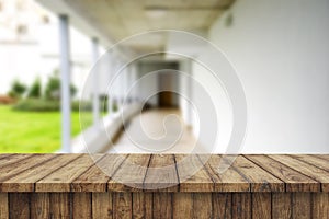 Wooden brown table top against the blurred corridor, passage and courtyard of the house .For product display montage or design is