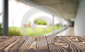 Wooden brown table top against the blurred corridor, passage and courtyard of the house .For product display montage or design is