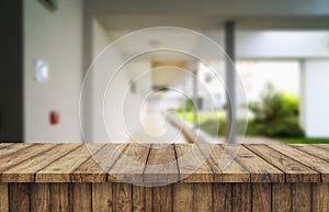 Wooden brown table top against the blurred corridor, passage and courtyard of the house .For product display montage or design is