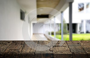 Wooden brown table top against the blurred corridor, passage and courtyard of the house .For product display montage or design is