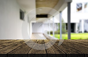 Wooden brown table top against the blurred corridor, passage and courtyard of the house .For product display montage or design is