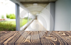 Wooden brown table top against the blurred corridor, passage and courtyard of the house .For product display montage or design is