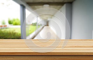 Wooden brown table top against the blurred corridor, passage and courtyard of the house .For product display montage or design is