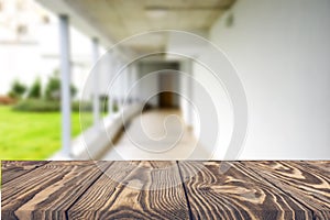 Wooden brown table top against the blurred corridor, passage and courtyard of the house .For product display montage or design is