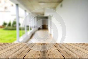 Wooden brown table top against the blurred corridor, passage and courtyard of the house .For product display montage or design is