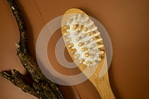 wooden brush for anticellulite massage on a brown table. still life, spa procedures, wellbeing