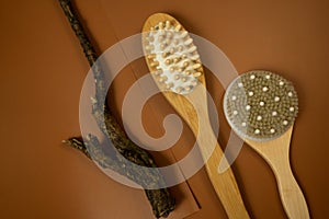 wooden brush for anticellulite massage on a brown table. still life, spa procedures, wellbeing mock up. close up.