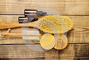Wooden brush for dry body massage,sponge, jars of oil. Anti-cellulite brush for body massage on a wooden background