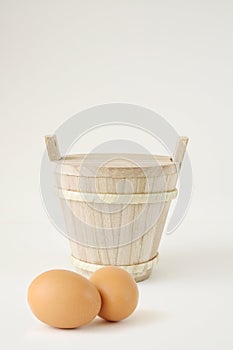 Wooden bucket with egg isolated on white background