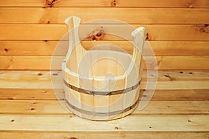 Wooden bucket for water in a Russian bath. Wood background