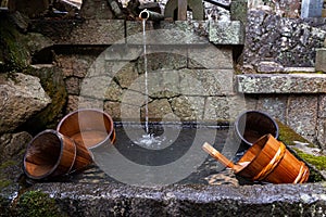 Wooden buckets in a fountain by the staircase to the entrance of Nigatsudo Nigatsu-Do temple, part of Todai-Ji in Nara, Japan