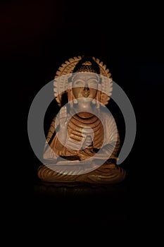 WOODEN BUDDHA STATUE IN LUMINANCE LIGHTING