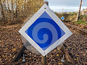 Wooden buffer stop with blue sign stop. The sign ending rail tracks