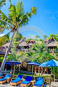 Wooden bungalows and blue sunloungers with umbrellas, Nusa Lembongan, Indonesia photo