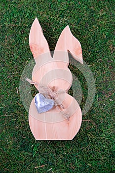 Wooden bunnies with a heart-shaped medallion on natural organic texture.