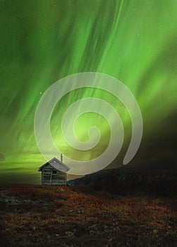 Wooden cabin in norwegian mountains called Sylan. Beautiful Aurora Borealis photo