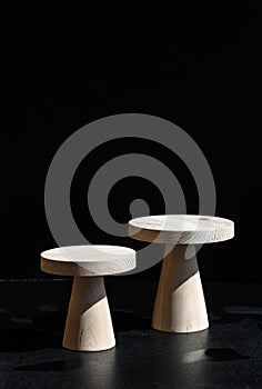 Wooden cakestands on black table on dark background