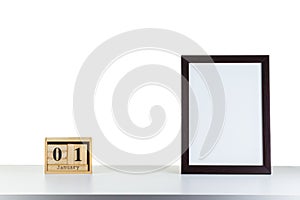 Wooden calendar 01 January with frame for photo on white table and background